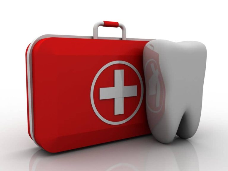A red first aid kit next to a large white tooth. A red first aid kit next to a large white tooth.
